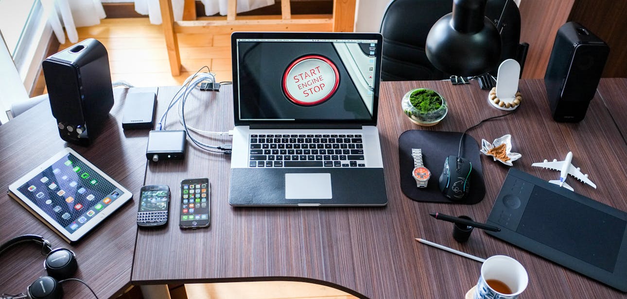A contemporary office desk setup with laptops, gadgets, and accessories, creating a tech-savvy workplace.