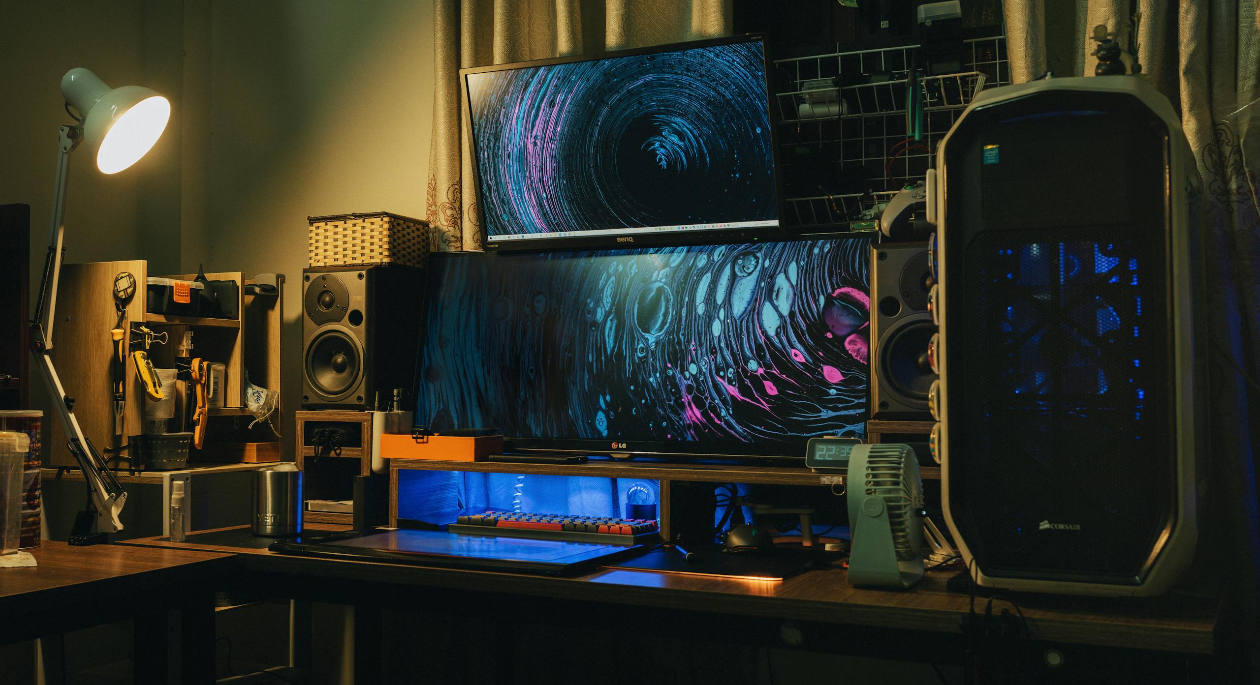 A cozy indoor modern computer setup with dual monitors and creative lighting.