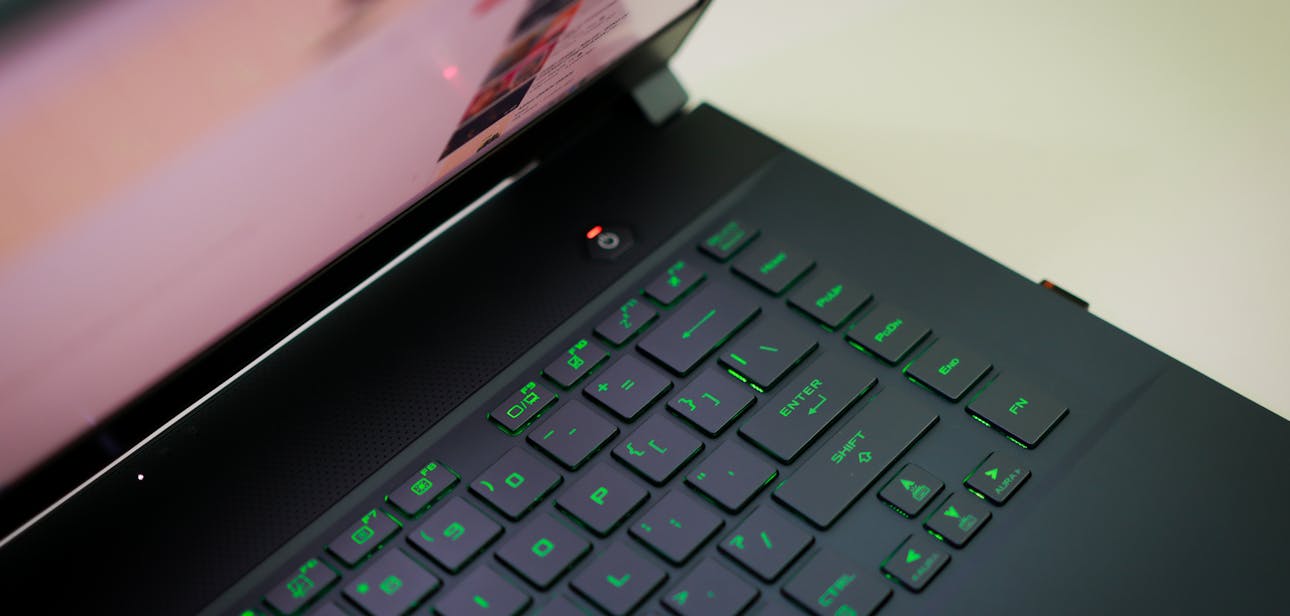 A sleek laptop with a glowing green keyboard illuminated, showcasing modern technology.