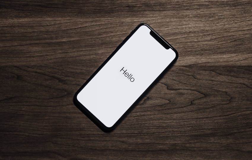 A smartphone displaying 'Hello' on a wooden surface, showcasing modern technology.