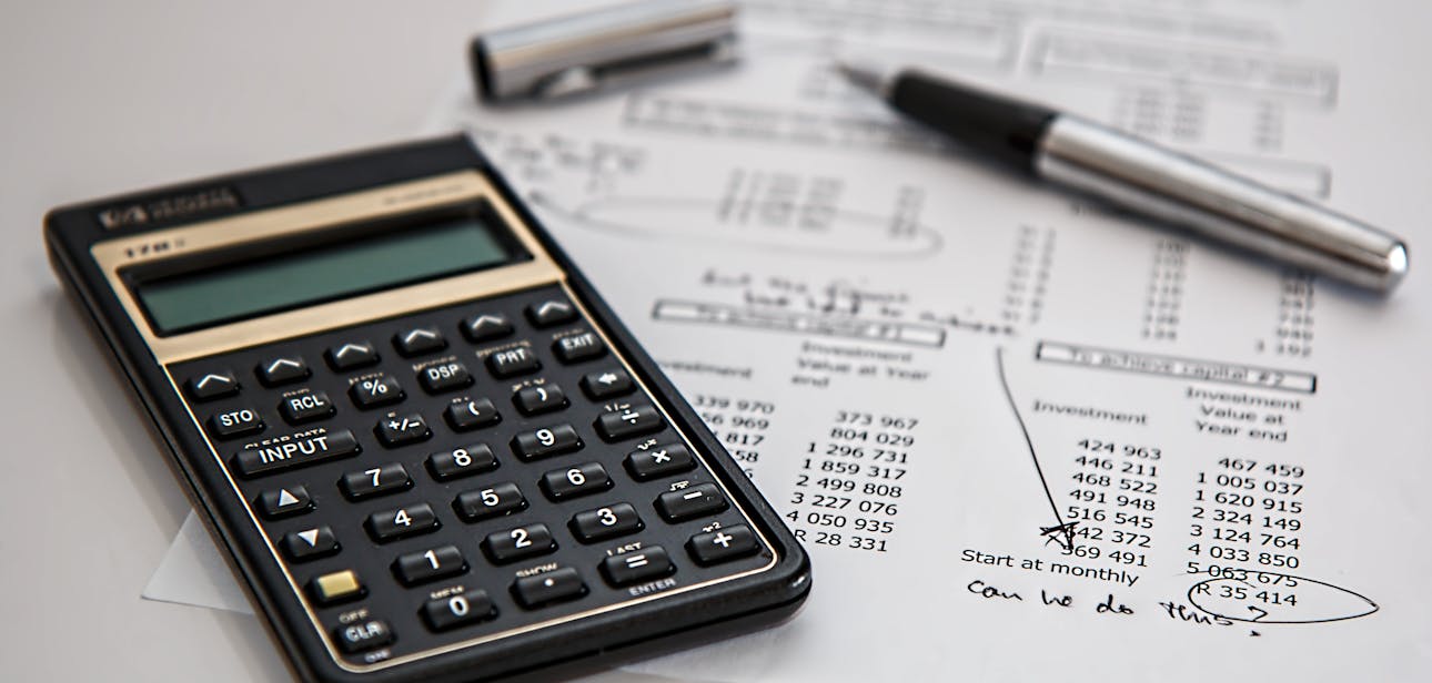 Close-up of financial documents with calculator and pen, ideal for business management themes.