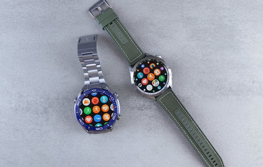 Close-up of two smartwatches on a gray background highlighting design and technology.