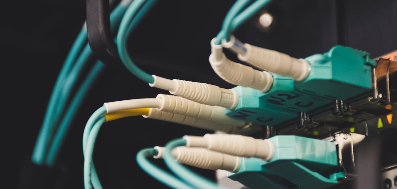 Detailed view of fiber optic cables and ports in a server room, showcasing connectivity.