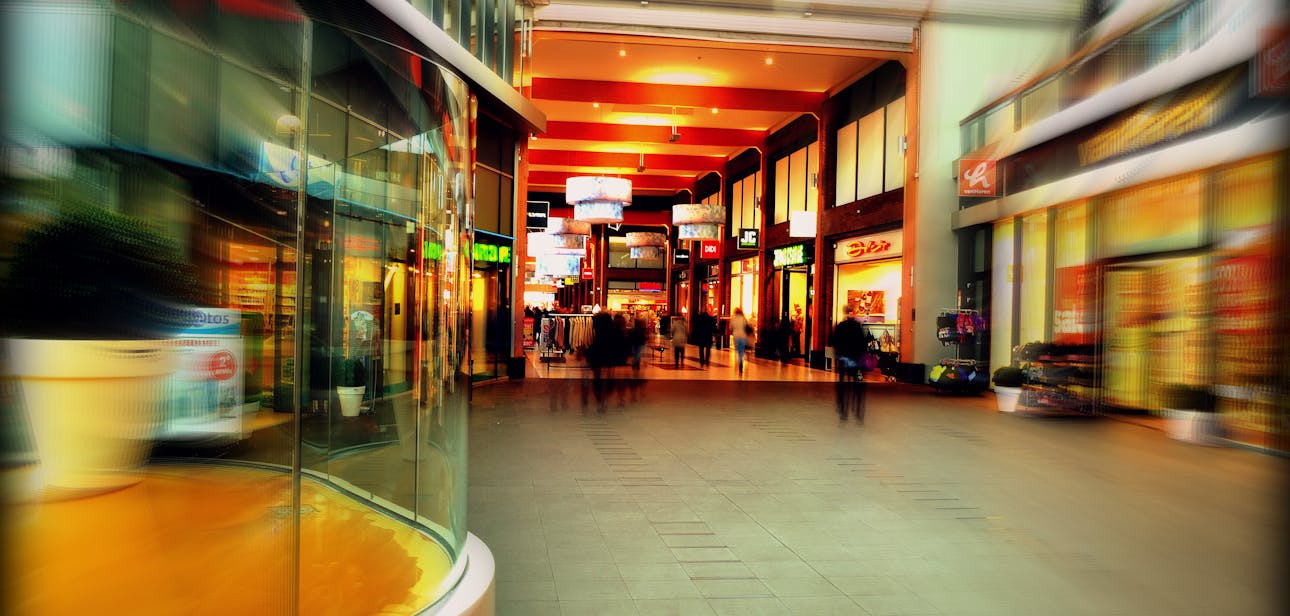 Explore the lively atmosphere of a modern shopping mall in Hoofddorp, Netherlands, captured with vibrant colors and motion blur.