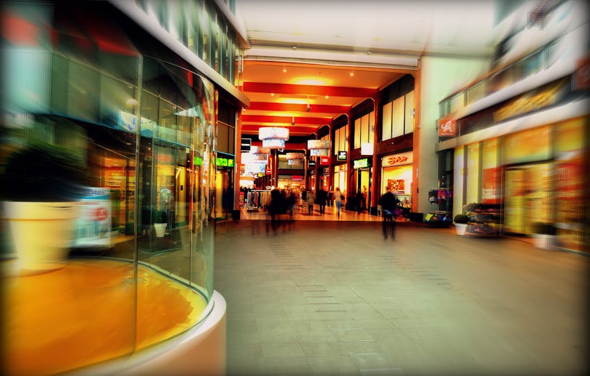 Explore the lively atmosphere of a modern shopping mall in Hoofddorp, Netherlands, captured with vibrant colors and motion blur.