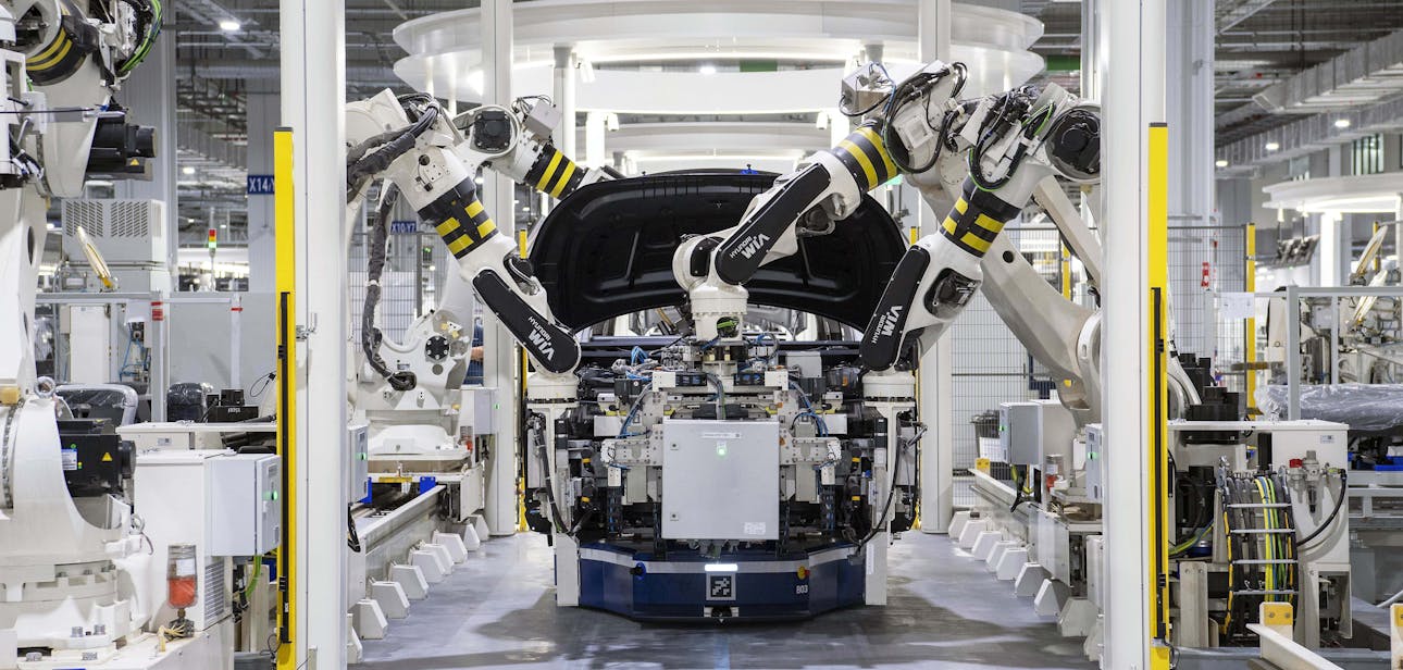 High-tech robots assembling a car in a modern factory setting, showcasing automation.