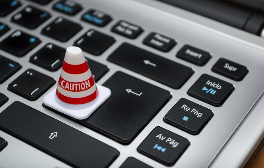 Miniature caution cone on a computer keyboard symbolizing data security and control.