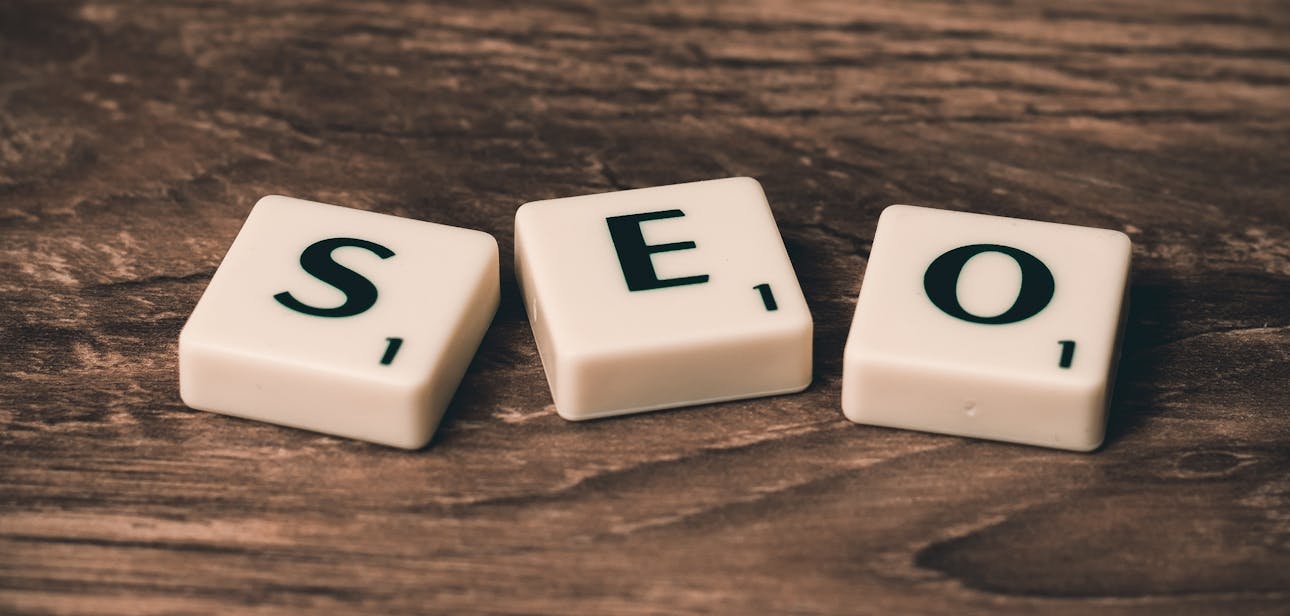 Scrabble tiles spelling 'SEO' on a wooden surface. Ideal for digital marketing themes.