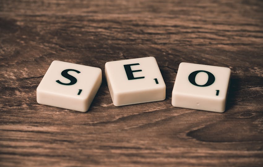 Scrabble tiles spelling 'SEO' on a wooden surface. Ideal for digital marketing themes.