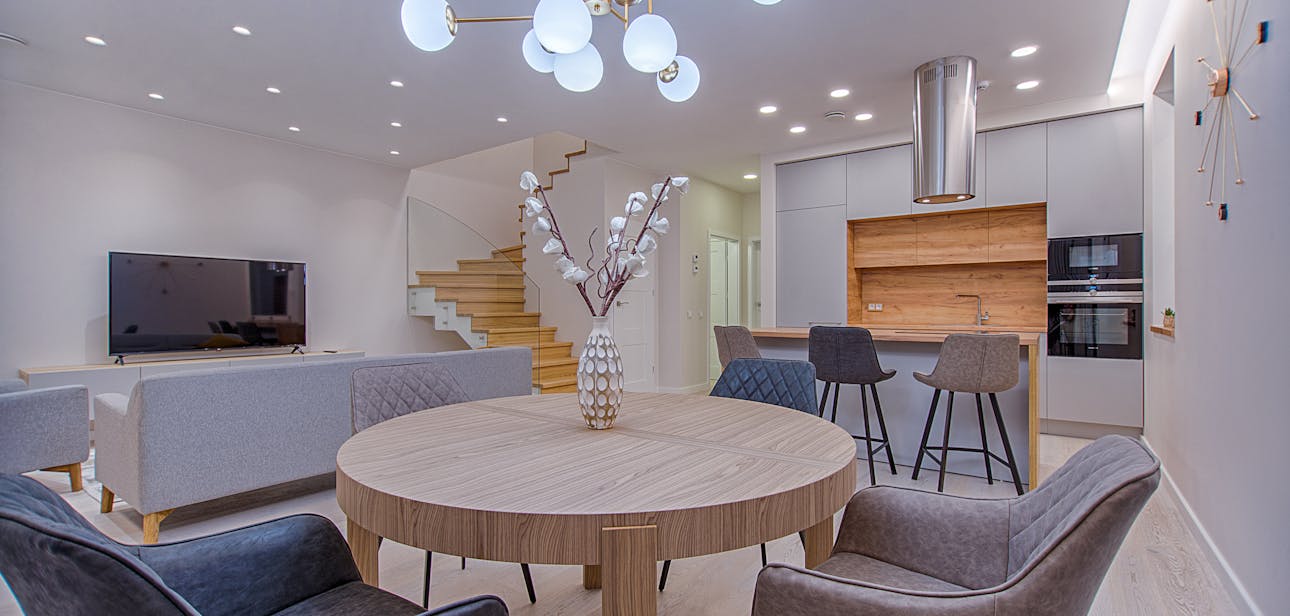 Stylish open-plan living room and kitchen with modern furnishings and lighting.
