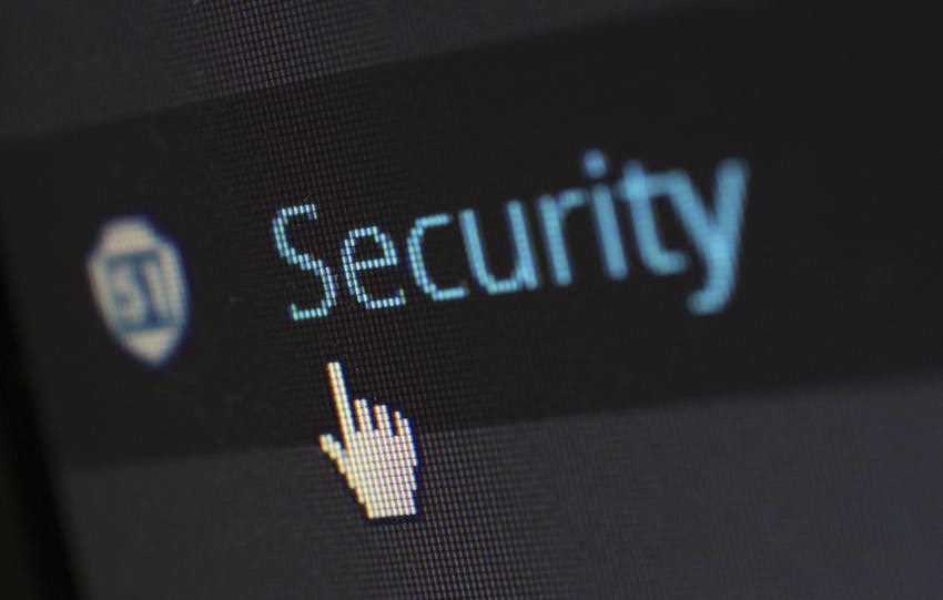 Close-up view of a mouse cursor over digital security text on display.